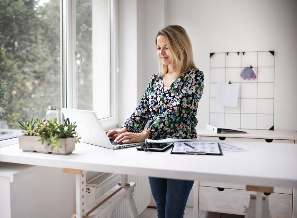 woman using laptop on standing desk